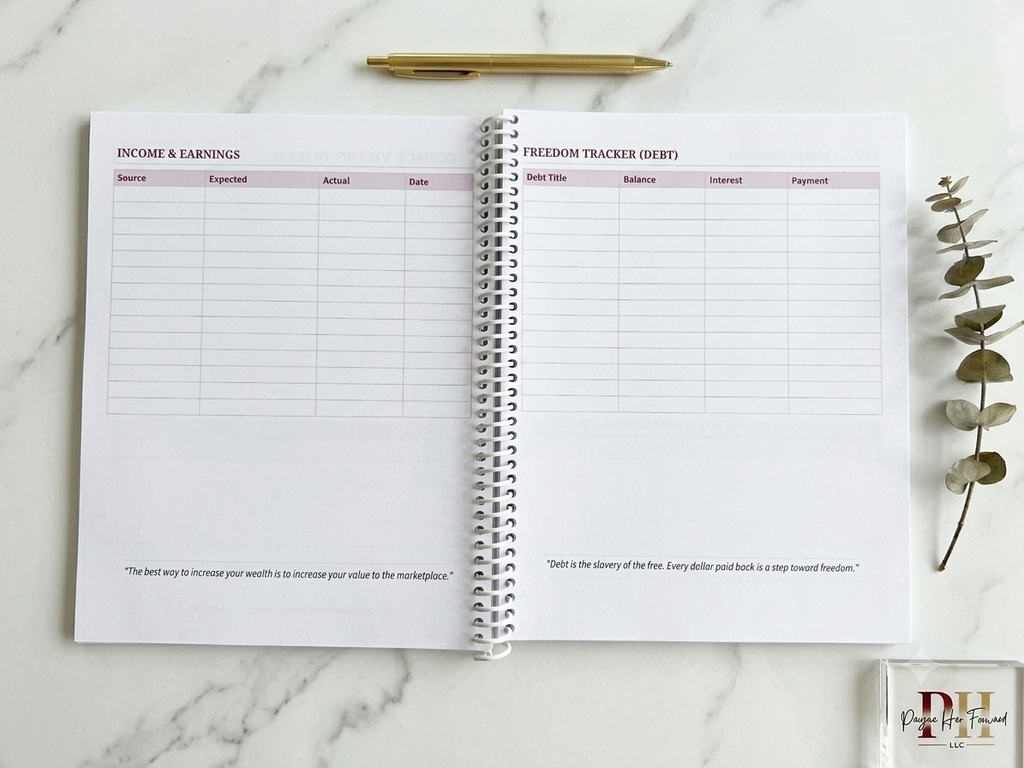 Open planner with income and earnings tracker on a marble surface with a pen and plant.
