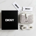 DKNY wallet with packaging and accessories on a marble surface