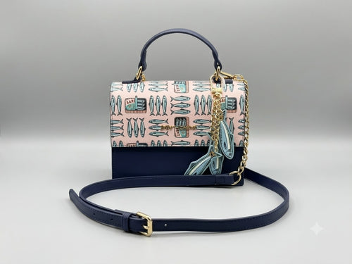 Designer handbag with a patterned flap and chain strap on a light gray background