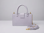 Light purple handbag with a matching strap on a light gray background