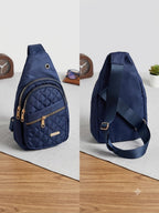 Navy blue quilted sling bag shown from front and side on a light gray surface.