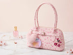 Pink handbag with cherry design on a light background