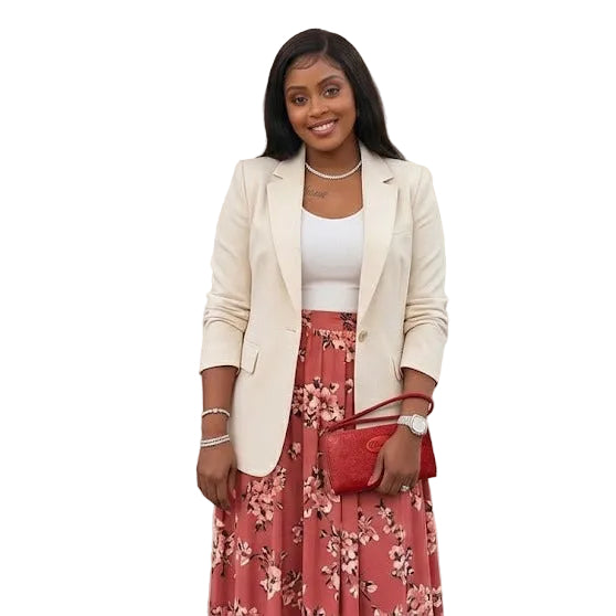 Woman in a stylish outfit with a red floral skirt and white blazer in a clothing store.