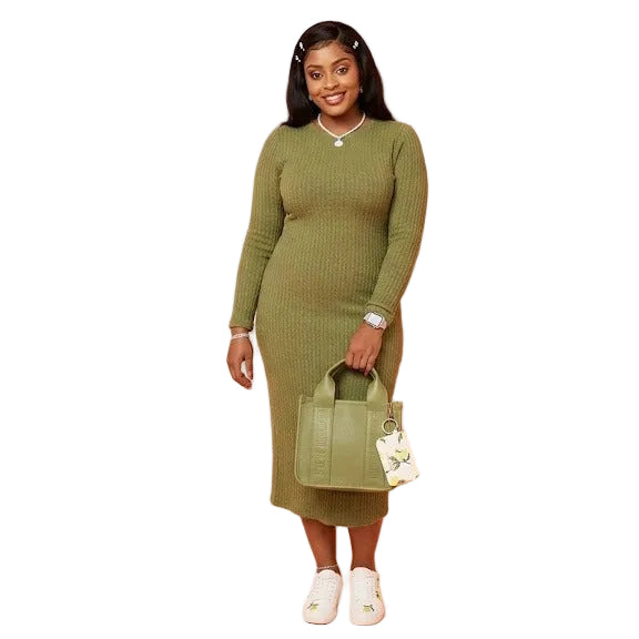 Woman wearing a green dress holding a matching handbag against a pink background