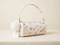White handbag with decorative patterns on a beige background