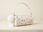 White handbag with decorative patterns on a beige background