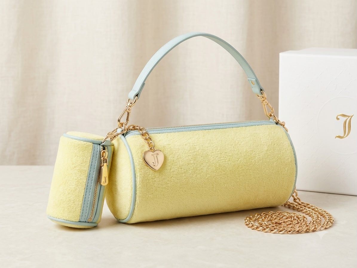 Yellow handbag with light blue accents and gold chain on a beige background