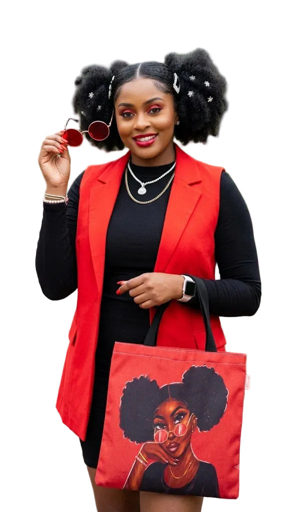 Woman holding a red tote bag with a graphic of a woman with styled hair, wearing a red vest and black top outdoors.